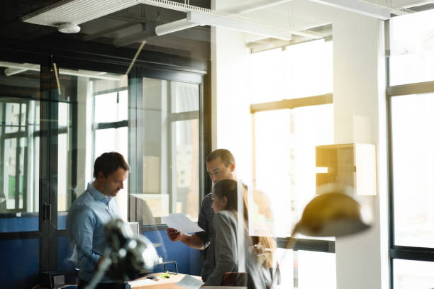 istock Business people discussing over document in office 641971708
