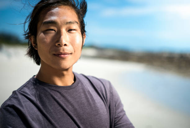 istock Portrait of young man smiling at beach 641971872