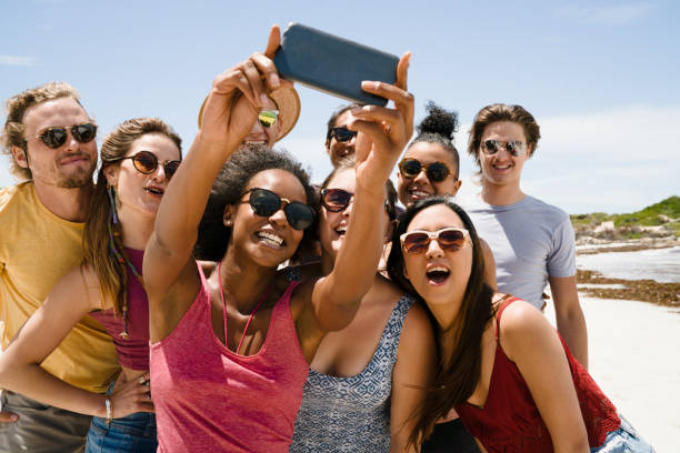 istock Friends taking selfie though mobile phone at beach 641972224