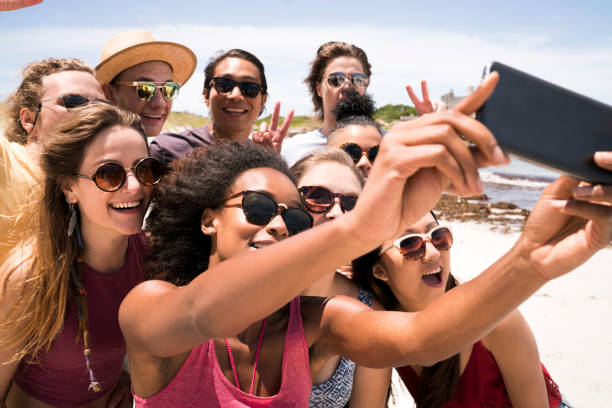 istock Friends taking selfie though smart phone at beach 641972226