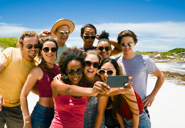 istock Happy friends taking selfie though mobile phone at beach 641972316
