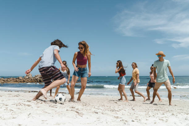 istock Happy friends playing soccer at beach 641972682