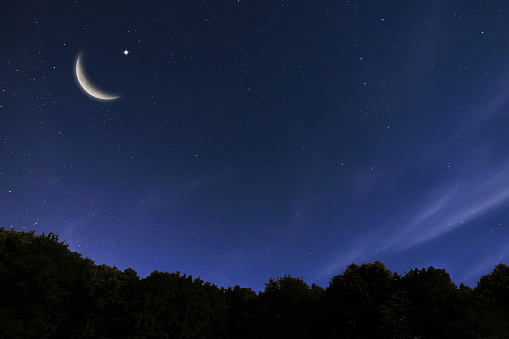 Rising moon over mountains against starry starry night