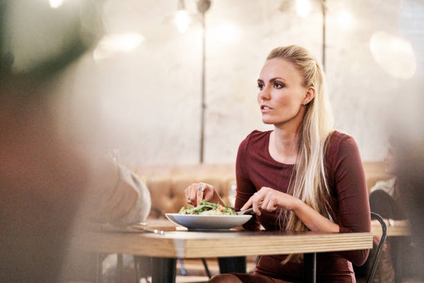 istock Woman talking while having food with man at table 641976398