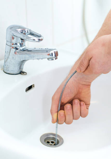 Plumber Repairing Sink With Plumbers Snake Stock Photo - Download Image Now  - Sewer, Snake, Drain - iStock
