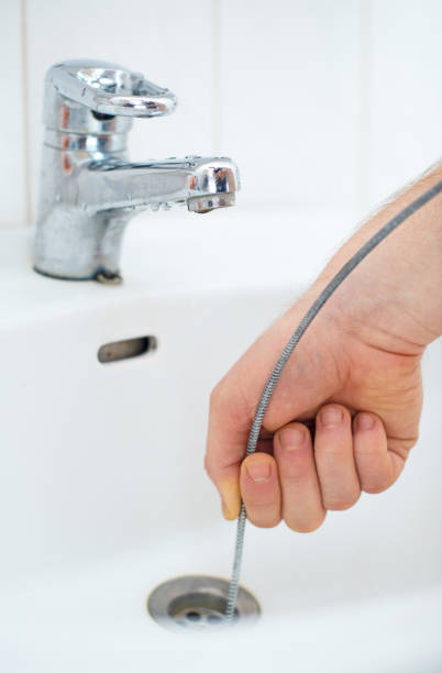 istock Plumber repairing sink with plumber's snake. 641976452