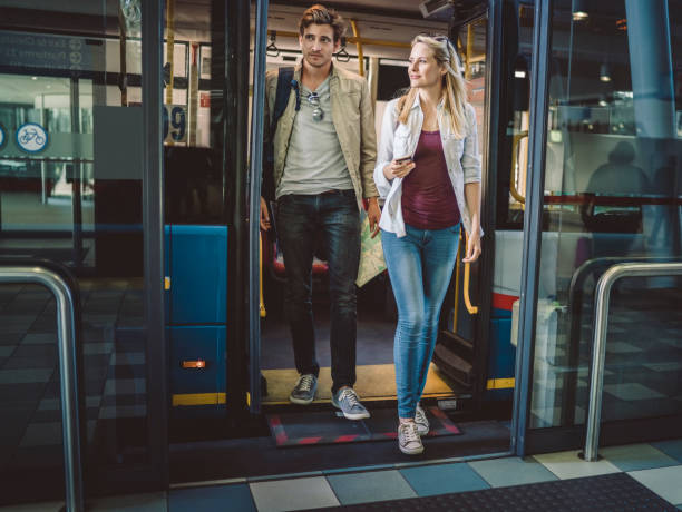 longitud total de joven pareja desembarque de autobús - bus door fotografías e imágenes de stock