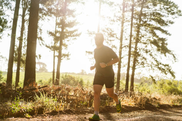 istock Sporty young man jogging on road during summer 641978740