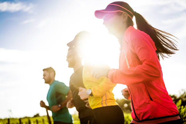 istock Determined woman jogging with friends on sunny day 641978834