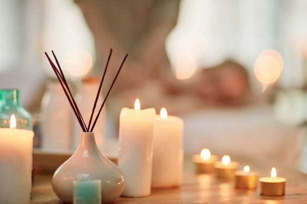 Invigorate your senses with a day at the spa Cropped shot of various pampering essentials in a spa with a young woman in the background incense photos stock pictures, royalty-free photos & images