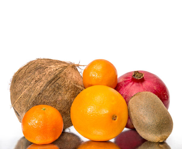 istock Coconut, pomegranate, orange, tangerine and kiwi on reflective background. 641983962