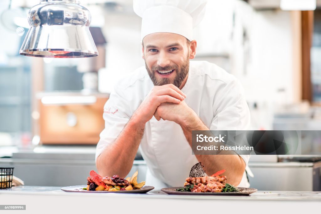 Chef cook at the kitchen Portrait of chef cook in uniform with prepaired delicious dish at the restaurant kitchen Chef Stock Photo
