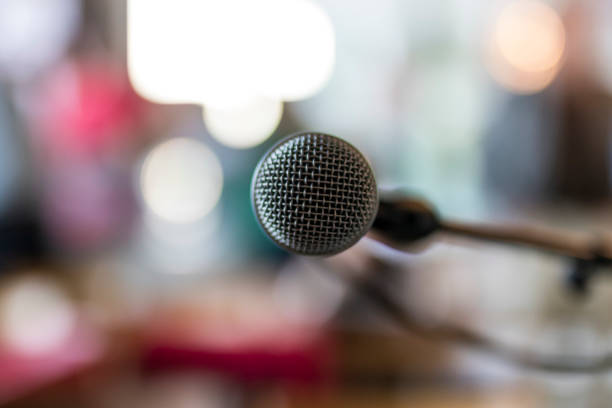 istock Close up of microphone with blurred abstract lights in background 641992134