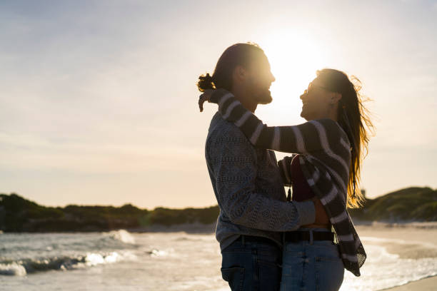 istock Romantic young couple embracing at beach 641994094