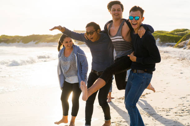 istock Playful young male friends at beach 641994224