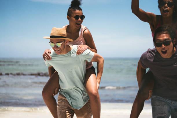 istock Young men piggybacking women at beach 641995002