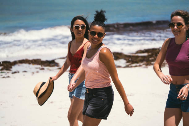 istock Happy female friends walking at beach during summer 641995088