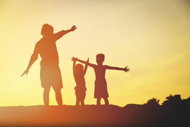 istock father with son and daughter silhouettes play at sunset 641995348