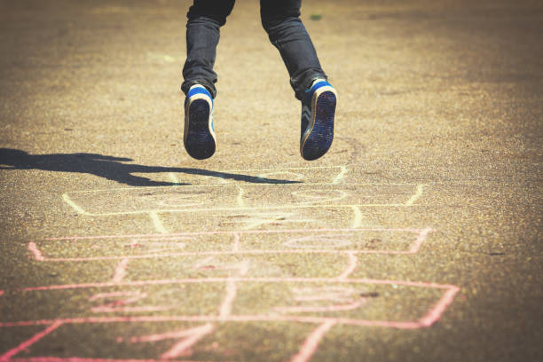 istock little boy playing hopscotch on playground 641996628