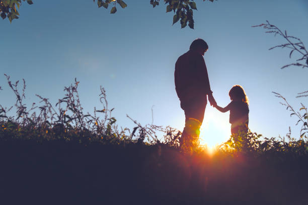 istock father with little daughter walk in sunset 641996752