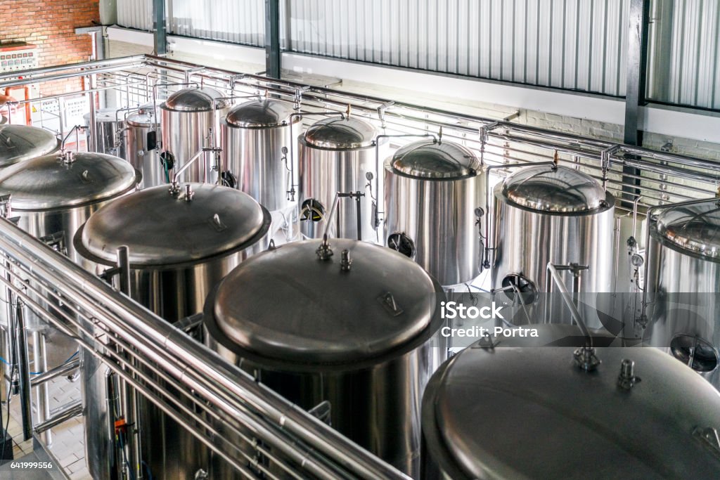High angle view of metallic vats in brewery Metallic vats in brewery. High angle view of steel containers in factory. Beer is stored in huge storage tanks at industry. Brewery Stock Photo