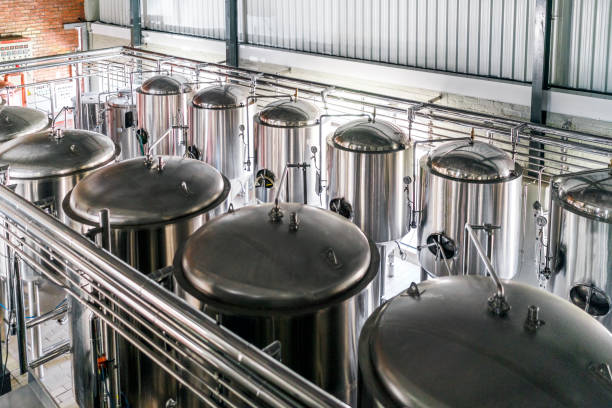 High angle view of metallic vats in brewery Metallic vats in brewery. High angle view of steel containers in factory. Beer is stored in huge storage tanks at industry. distillery photos stock pictures, royalty-free photos & images