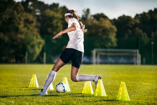 jugadora de fútbol femenino - entrenamiento de ejercicios de slalom - clothing team sport serious viewpoint fotografías e imágenes de stock