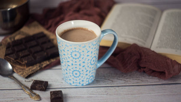istock Cup of Hot chocolate with spoon, book and chocolate pieces. Cozy composition 642003288