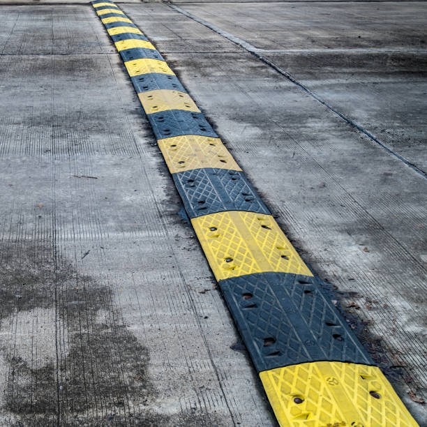 istock Yellow and black speed bump on concrete road 642003838