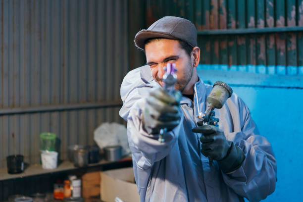 istock Bearded craftsman holding paint gun 642006038