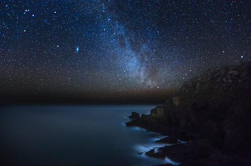 A tranquil night scene showing Botallack Mine under a starry night sky. The mines are no longer used and are currently part of the UNESCO World Heritage Site. A popular location for visitors and tourists.