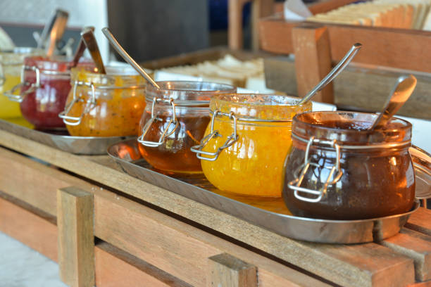 Varieties of jams in glass jars with spoon