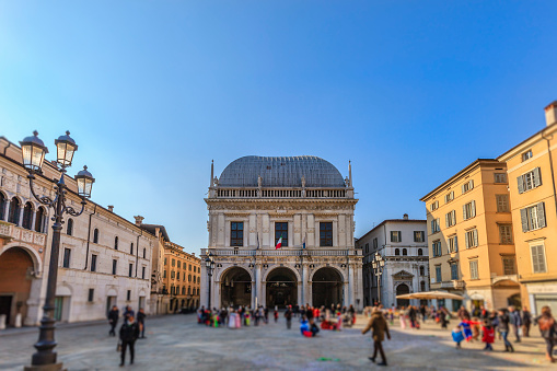Piazza della Loggia is a rectangular square dating from the fifteenth century, bordered by a series of Venetian era buildings including the Loggia, the seat of the City Council of Brescia, and the clock tower. (Lombardy, Italy) (selective focus)