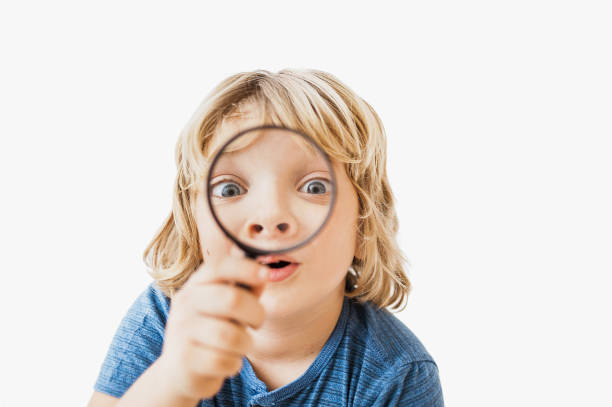 Little boy looking through magnifier Lens