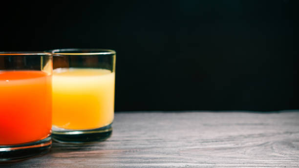 istock Grapefruit and orange juices on dark background 642011796