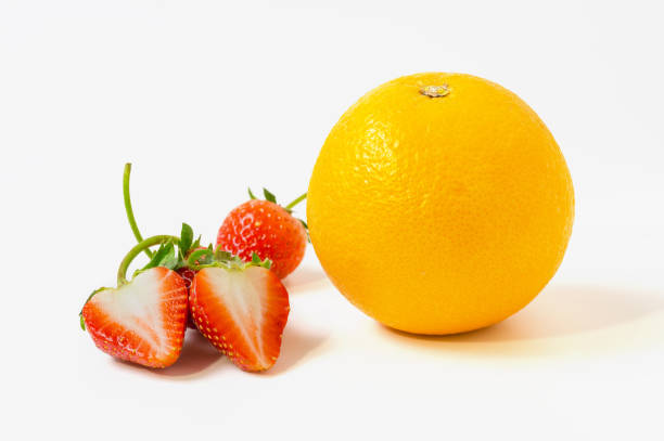 istock close up Strawberries and orange fruit isolated on white background 642012616
