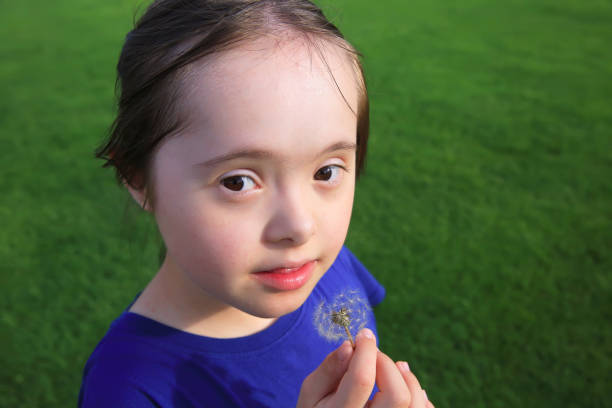 Little girl blowing dandelion