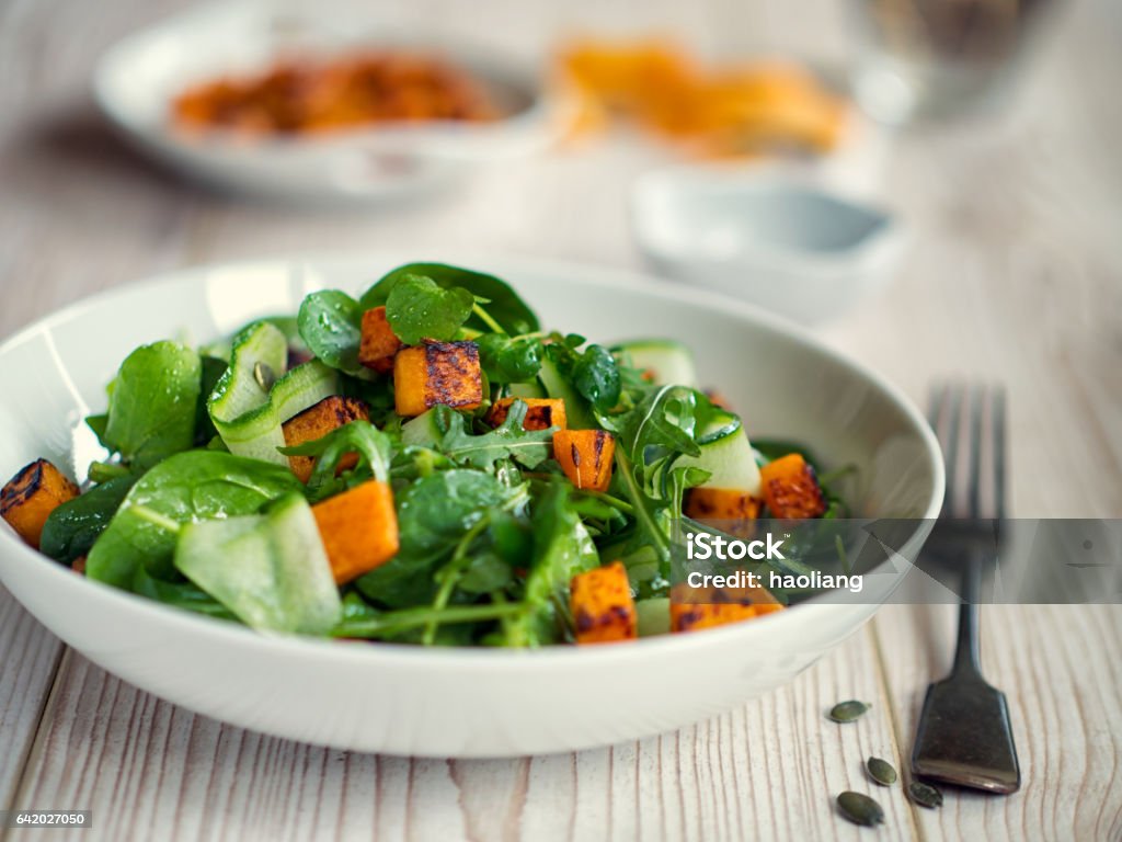 Healthy green salad with roasted butternuts squash Home made  house  healthy salad,cumin roasted butternuts squash with mix leaves,cumcumber and pumkin seeds Salad Stock Photo