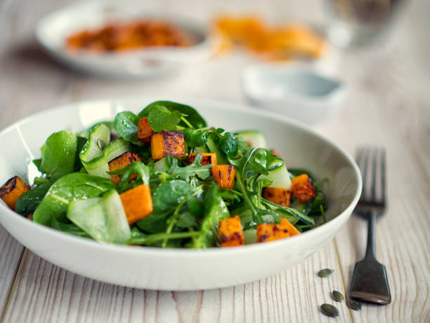 Healthy green salad with roasted butternuts squash stock photo