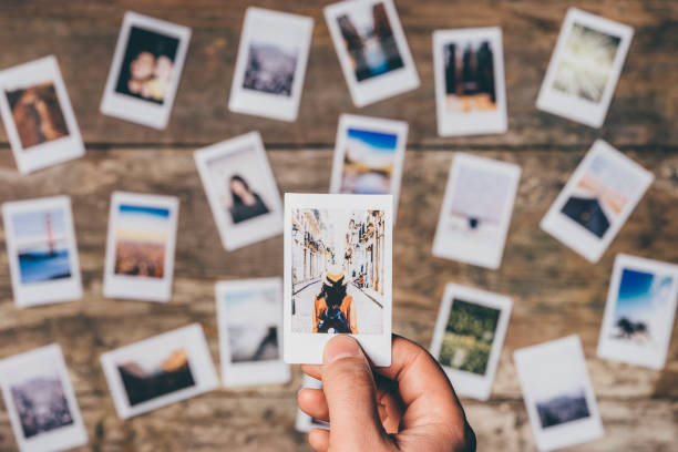 Instant camera prints on a table Instant camera prints on a table. Top view. photo album photos stock pictures, royalty-free photos & images