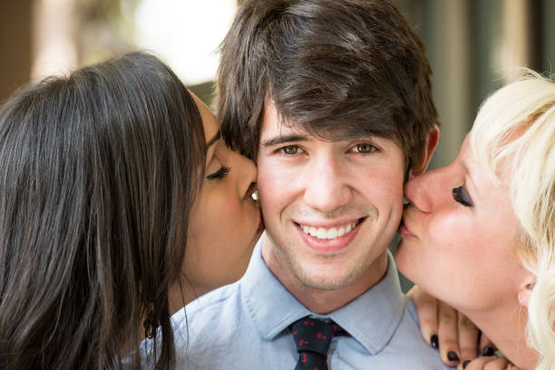 Lucky man Lucky man being kissed by two young women mormon woman photos stock pictures, royalty-free photos & images