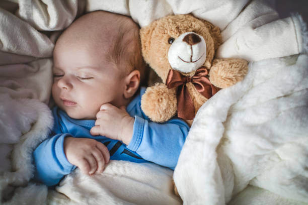 newborn baby boy sleeping together with teddy bear - baby blanket imagens e fotografias de stock