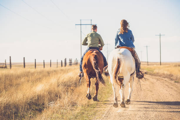 Young Couple Riding Away On Horseback