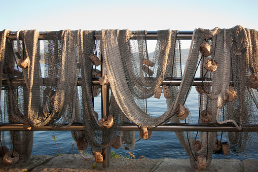 Front view of buoys and fishing nets hanging to dry by the sea in the sunlight in Combarro, Ría de Pontevedra, Rías Baixas, Galicia, Spain.