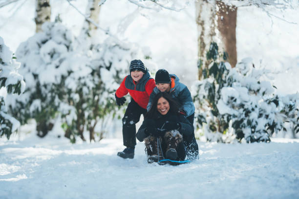 istock Mom and sons playing in snow 642050052