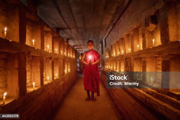 Novice Monk Praying Inside Temple Full Burning Candles Bagan Myanmar Stock Photo - Download Image Now