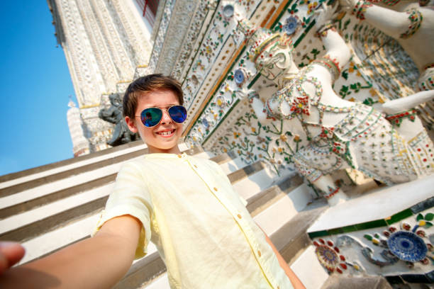 Cute little boy taking a selfie at temple Wat Arun, Thailand, Asia