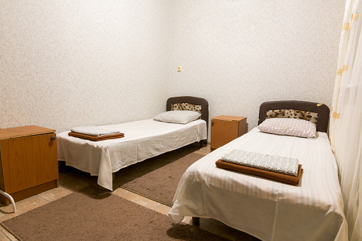 The interior of a small room with two beds