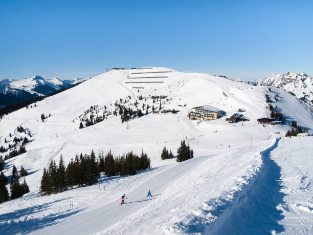 cuesta abajo y caba�ña de montaña de esquí apres con terraza restaurante en saalbach hinterglemm leogang winter resort, tirol, austria, europa. tiro de día soleado - ski resort hut snow winter fotografías e imágenes de stock