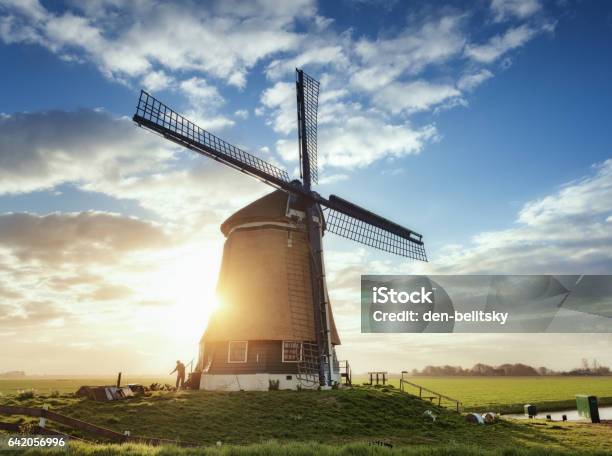 Windmill And Silhouette Of A Man At Sunrise In Netherlands Stock Photo - Download Image Now